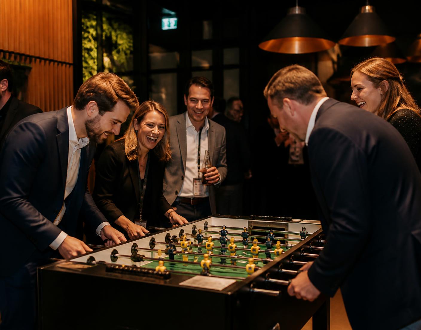 Gäste spielen an einem Firmenevent gemeinsam am Tischfussball